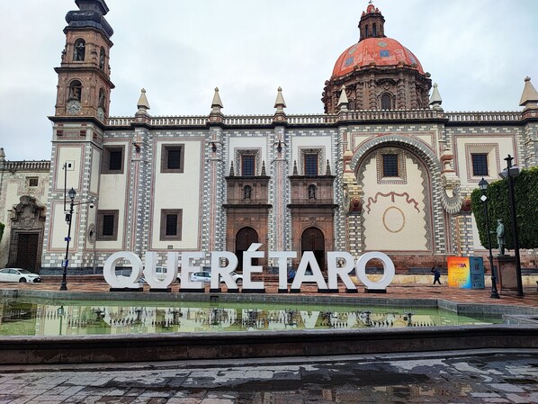 A historic building with a prominent clock tower and a large dome. - Hospedaje Castillo (Santiago de Querétaro)