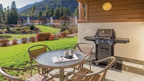A patio with a round table, chairs, and a grill. - Enjoy Oktoberfest in this Charming 2-bedroom condo in fabulous Leavenworth (Leavenworth)