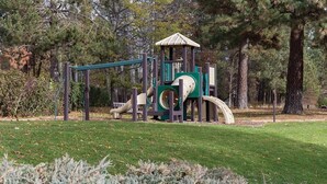 A playground with a slide and climbing structures, surrounded by trees and a grassy area. - Enjoy Oktoberfest in this Charming 2-bedroom condo in fabulous Leavenworth (Leavenworth)