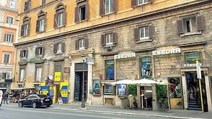 A multi-story building with a ground-floor shop named 'ESEDRA' and a hotel named 'HOTEL REPUBBLICA' on the left. - Hotel Domus Rome (Rome)