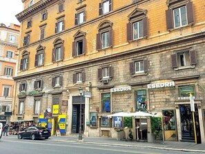 A multi-story building with a ground-floor shop named 'ESEDRA' and a hotel named 'HOTEL REPUBBLICA' on the left. - Hotel Domus Rome (Rome)