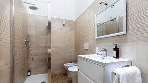 A modern bathroom with a glass-enclosed shower, a toilet, and a vanity with a mirror. - Hotel Domus Rome (Rome)