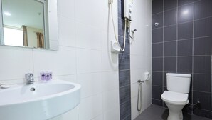 A bathroom with a white sink, a mirror, a toilet, and a shower. - Fast Hotel Sri Gombak By Zuzu (Batu Caves)