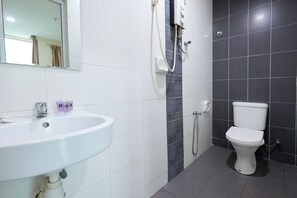 Ein Badezimmer mit Waschbecken, Spiegel, Toilette und Dusche.