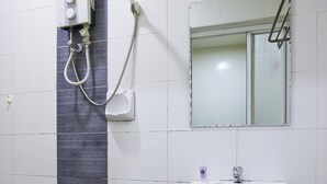 A bathroom with a white sink, a mirror, and a shower unit. - Fast Hotel Sri Gombak By Zuzu (Batu Caves)