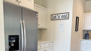 A kitchen with white cabinets, a stainless steel refrigerator, and a wooden floor. - Charming 2-bedroom house-Walk to Helen-Your Perfect Getaway (Helen)