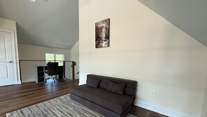 A spacious living room with a dark brown sofa, a patterned rug, and a painting on the wall. - Charming 2-bedroom house-Walk to Helen-Your Perfect Getaway (Helen)