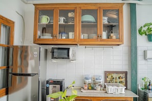 Une cuisine avec des meubles en bois, un four à micro-ondes, un grille-pain et un réfrigérateur.