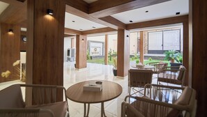 A spacious lobby with wooden paneling, a reception desk, and a view of the garden. - Merak Pyramids View Hotel (Giza)