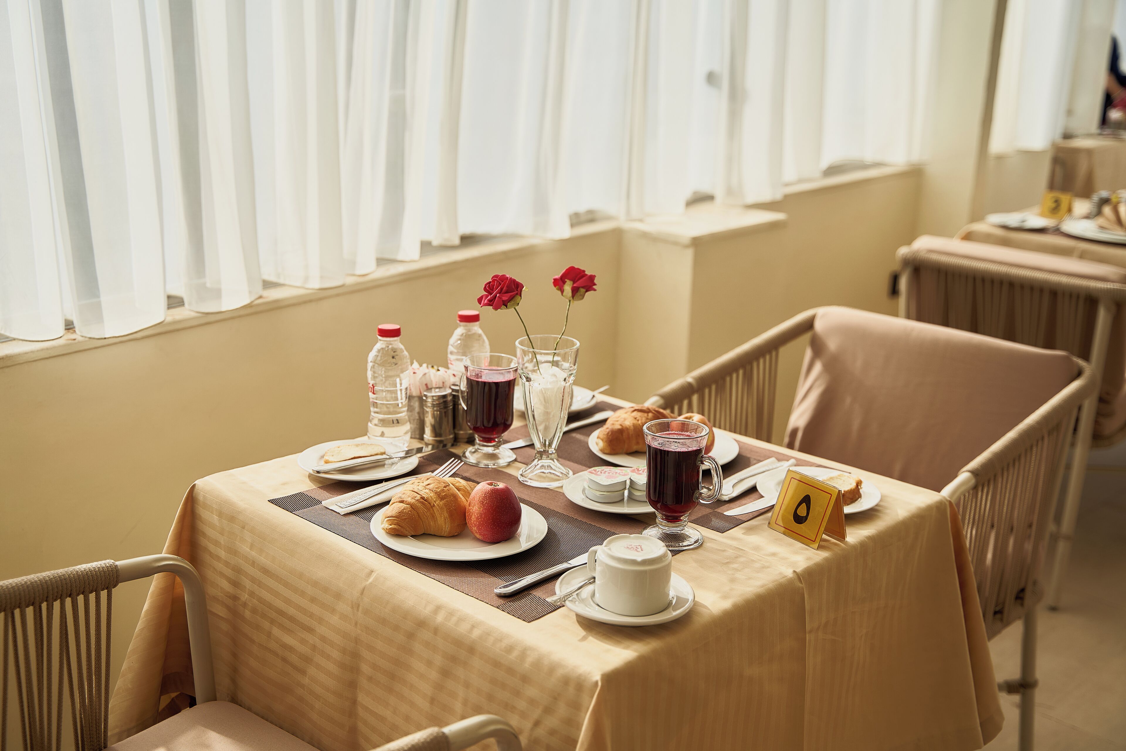 A table set for breakfast with croissants, fruit, and beverages.