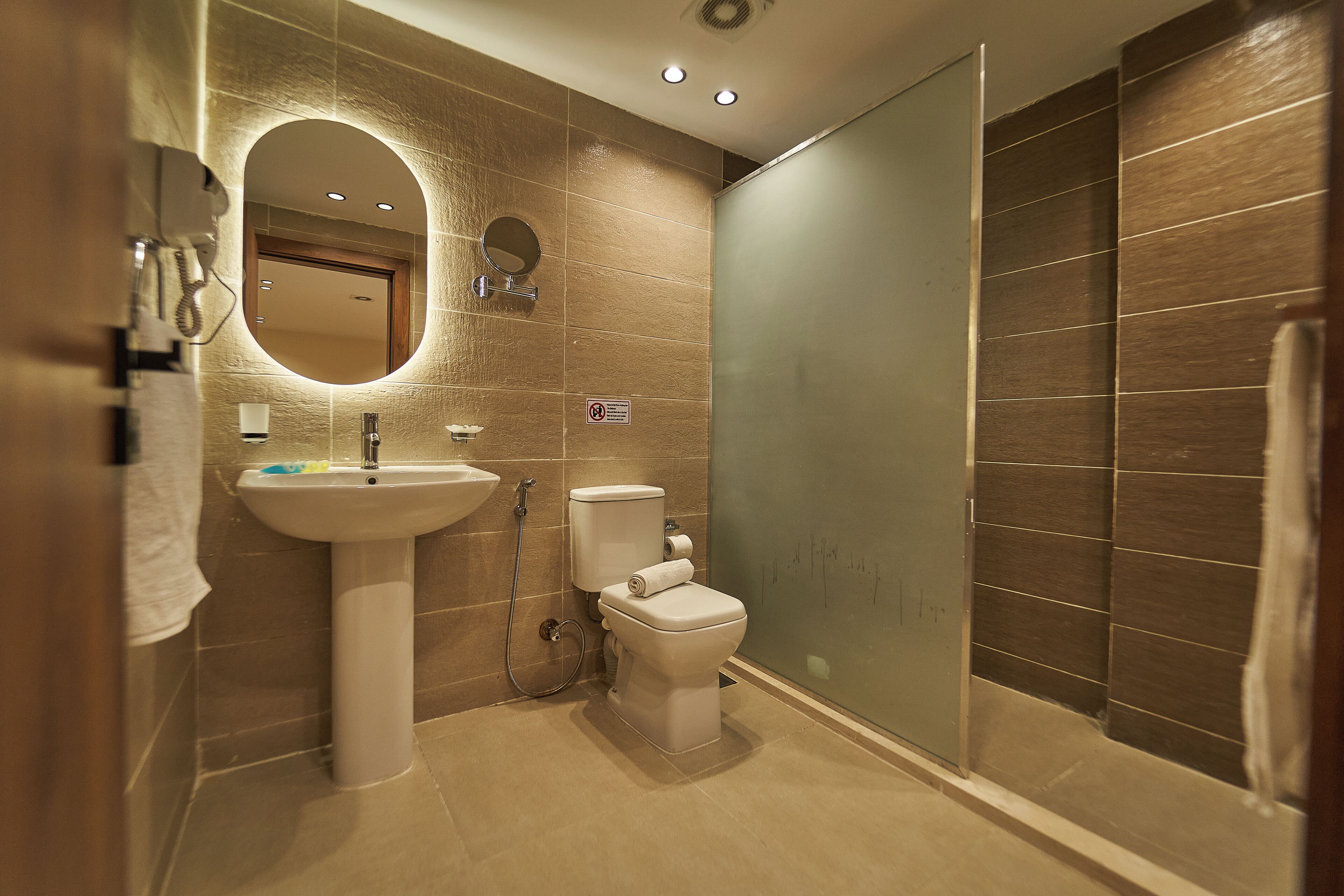 A modern bathroom with a sink, toilet, and glass shower enclosure.