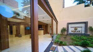 A hotel lobby with a reception desk, a television, and a sign with the name 'MIRAK'. - Merak Pyramids View Hotel (Giza)