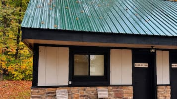 A building with a green roof, stone walls, and two doors labeled 'Bluebird Nest Studio.'