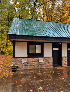 A building with a green roof, stone walls, and two doors labeled 'Bluebird Nest Studio.' - Bluebird Nest Studio Near Lake Michigan and Manistee River - Janix Escapes (Wellston)