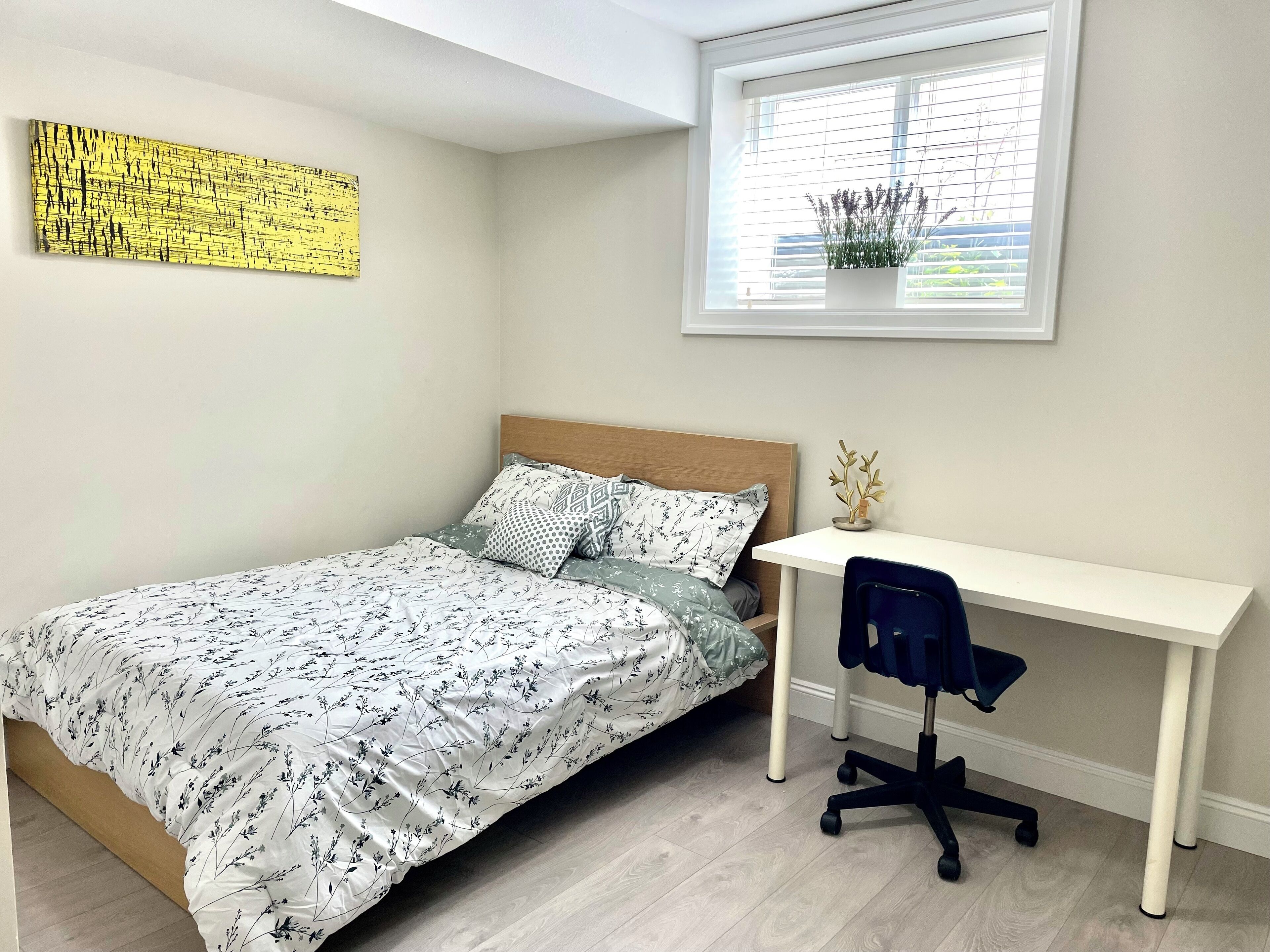 Ein Schlafzimmer mit Bett, Schreibtisch und Stuhl.