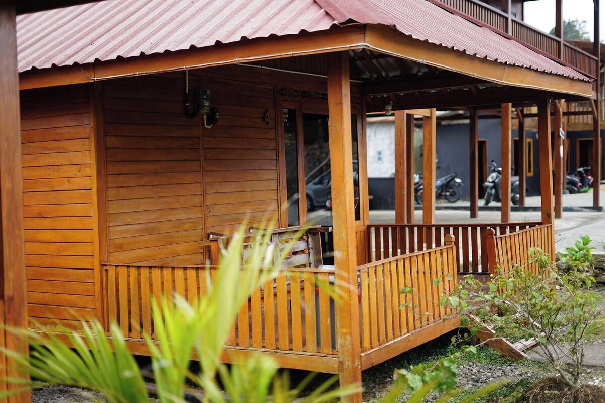 A wooden building with a porch and a corrugated metal roof.