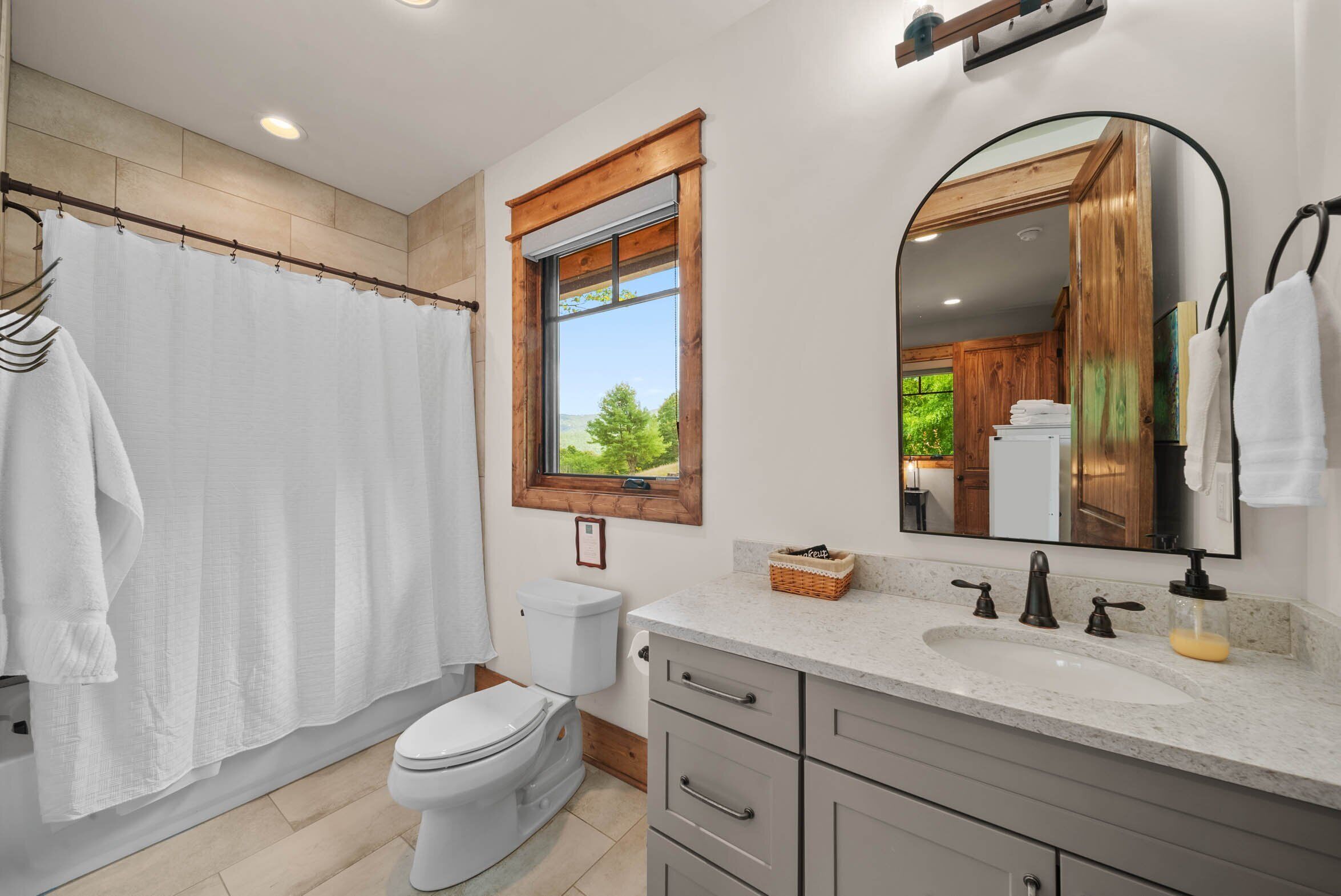 Une salle de bain moderne avec des toilettes, un lavabo et un grand miroir.
