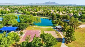 Vue aérienne d’un quartier résidentiel avec des maisons, un terrain de basket-ball et une piscine.