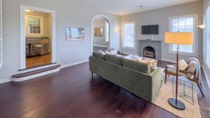 A spacious living room with a sofa, a lamp, and a fireplace.