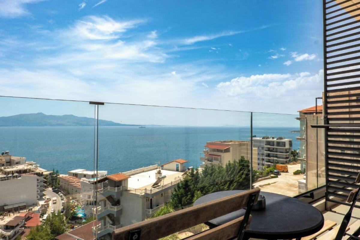 A balcony with a view of the sea and buildings.