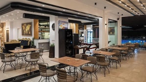 Un restaurant modern amb una zona de bar, taules i cadires.