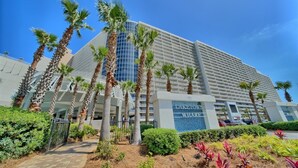 Un hotel moderno con una torre central, palmeras y un letrero que dice "LAKE TOWN WHARF".