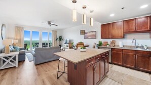 Una cocina moderna con armarios de madera, una isla central e iluminación colgante.