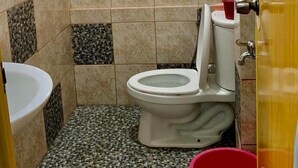 Une petite salle de bain avec des toilettes, un lavabo et une fenêtre.