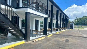 A motel with a two-story structure, a covered outdoor seating area, and a parking lot. - Gardenview (Tampa)