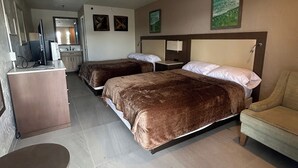 A hotel room with two beds, a desk, a chair, and a small table. - Gardenview (Tampa)