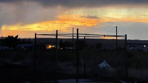 A fenced area with a sunset in the background. - Cozy 2-bedroom RV in enchanting Carrizozo with AC on 5.5 acres! (Carrizozo)