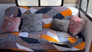 A cozy RV interior with a bed featuring a patchwork quilt and patterned pillows. - Cozy 2-bedroom RV in enchanting Carrizozo with AC on 5.5 acres! (Carrizozo)