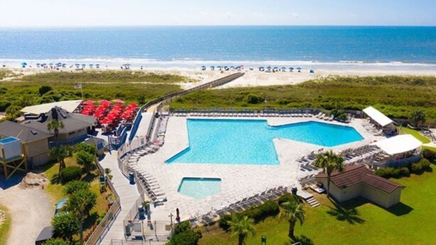 A resort with a large swimming pool, beach access, and a view of the ocean. - Beach Front with Ocean View (Hilton Head Island)