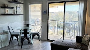A living room with a dining area, a sofa, and a balcony with a view. - Beach Front with Ocean View (Hilton Head Island)