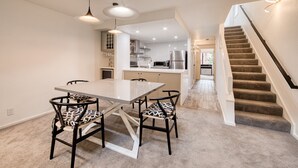 Una cocina moderna con armarios blancos, un refrigerador de acero inoxidable y un microondas.