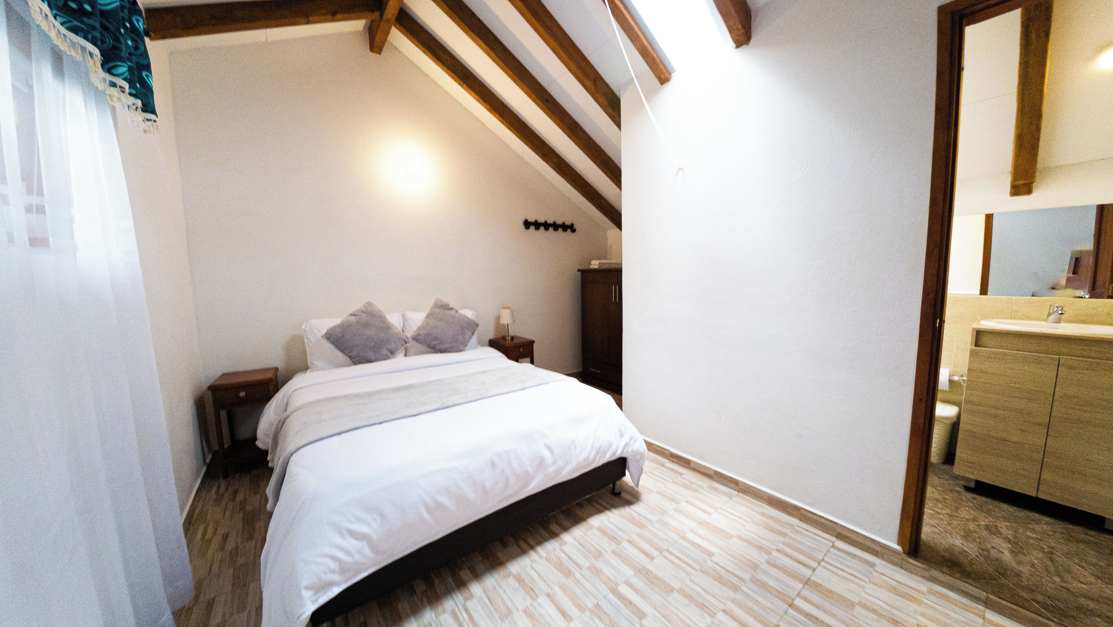 A bedroom with a bed, bedside table, and a wardrobe.