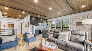 A spacious living area with a modern kitchen, leather sofas, and a rustic ceiling. - The Loft 7- Steps from the Lake & Dining- Newly renovated in the heart of McCall (McCall)