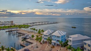 A waterfront property with multiple buildings, a dock, and a pier extending into the water. - Emerald Shores – Luxury Oceanfront Rental, Heated Pool & Private Dock. Pets Welcome! (Marathon)