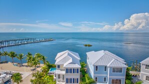 A coastal property with a beach, a pier, and a pool. - Emerald Shores – Luxury Oceanfront Rental, Heated Pool & Private Dock. Pets Welcome! (Marathon)