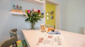 A dining table with a newspaper, a glass of beer, croissants, and a vase of flowers. - Mount Pleasant Farm, Dunwich (Dunwich)