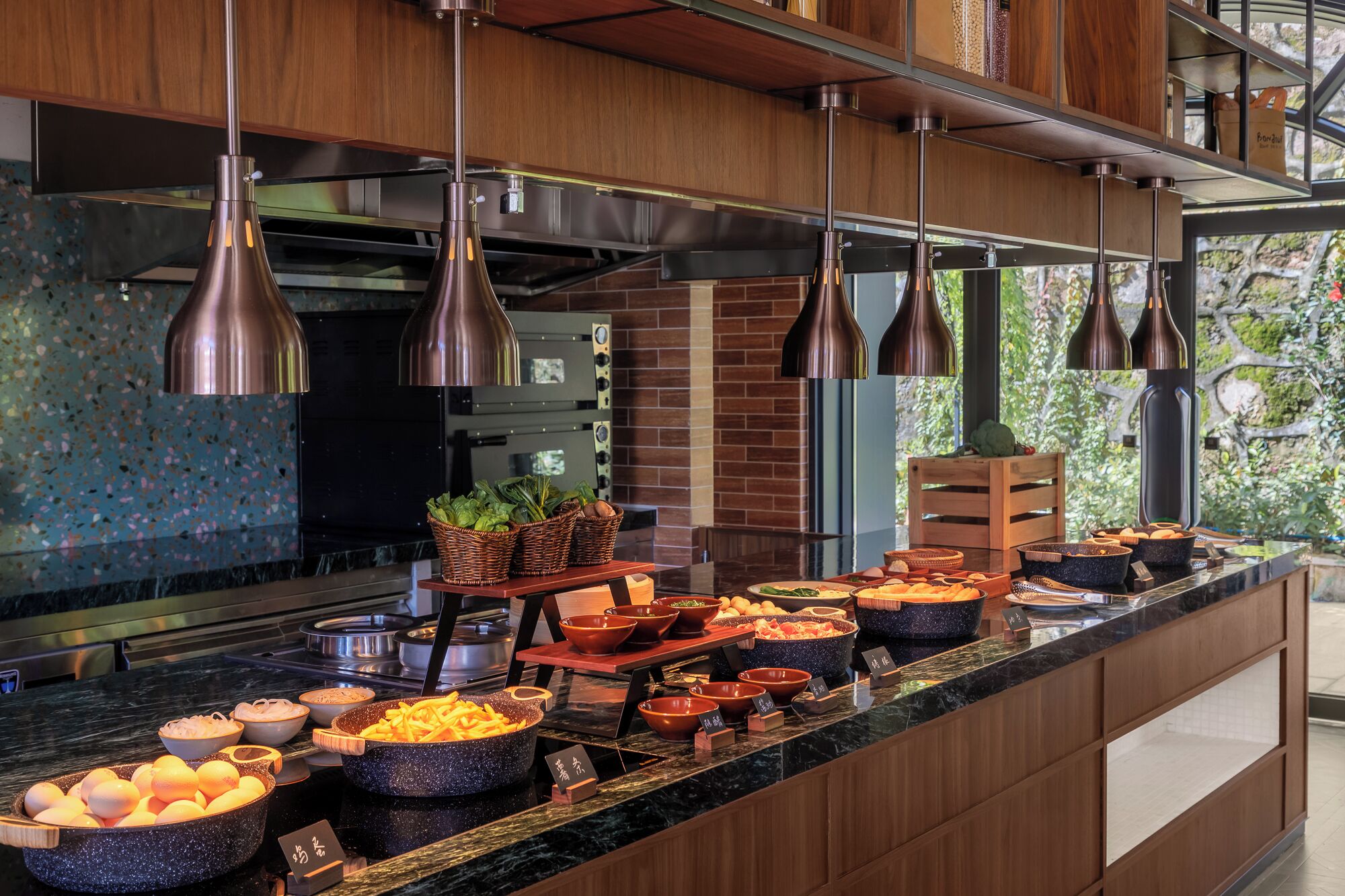 A buffet with various food items and baskets of greens.