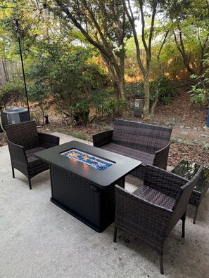 An outdoor patio with wicker furniture and a glass-top table.