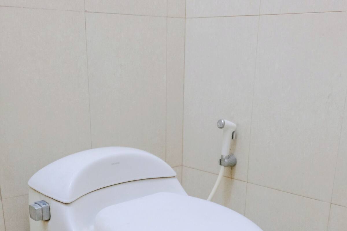 A white toilet in a bathroom with tiled walls and floor.