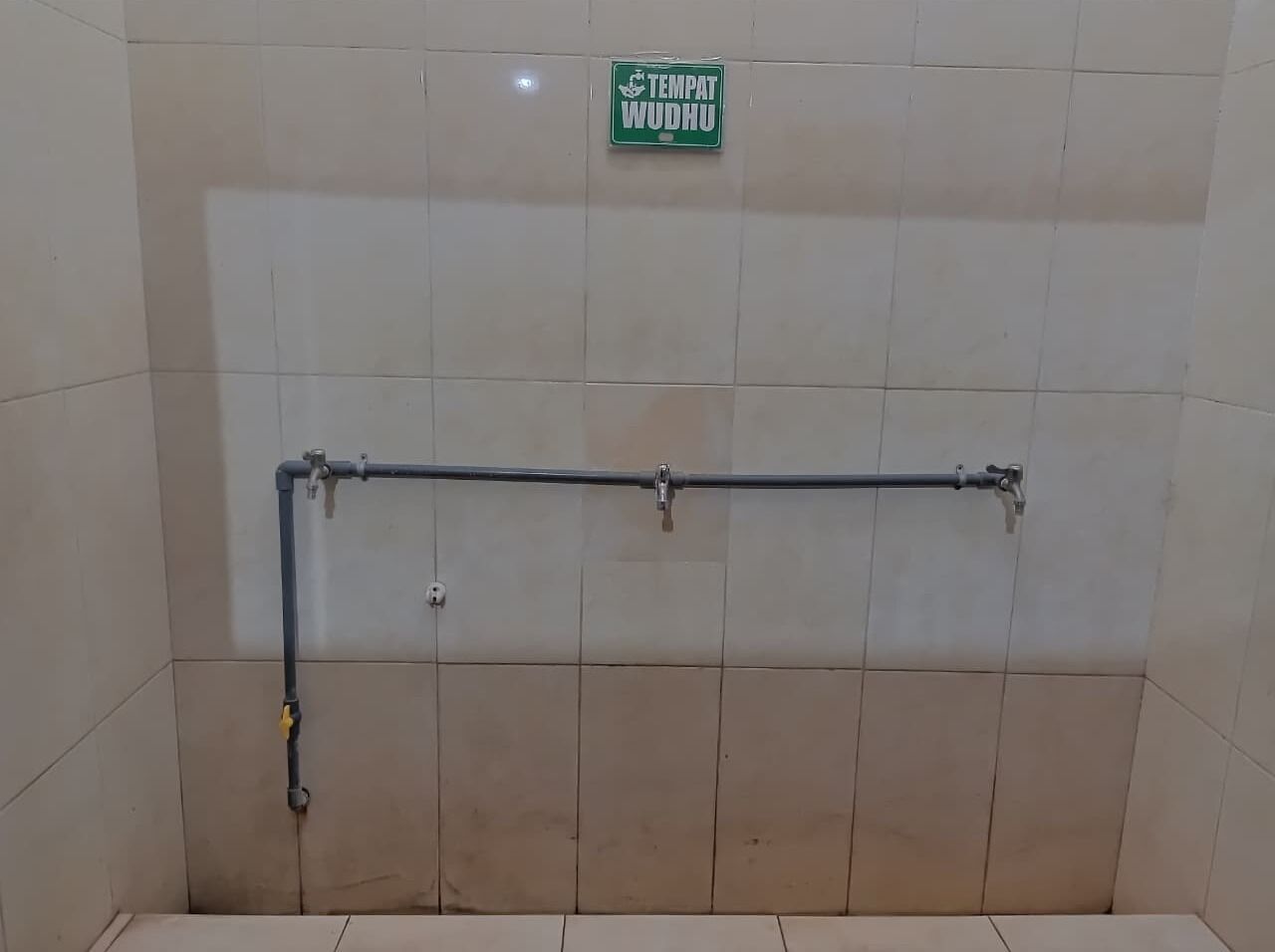 Uma área de chuveiro com uma placa verde com a inscrição 