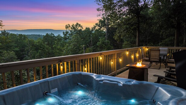 Un jacuzzi en una terraza con vistas a las montañas.
