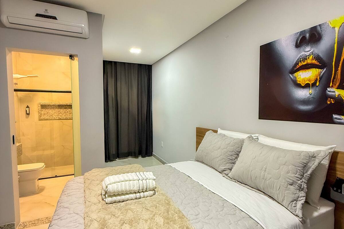 Une chambre d’hôtel moderne avec un grand lit, un espace douche et un tableau au mur.