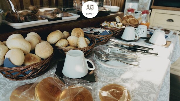 A breakfast buffet with various breads, pastries, and pancakes.