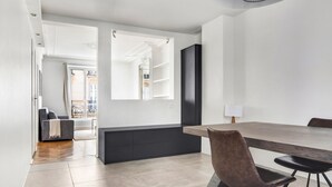 Ein moderner Essbereich mit einem langen Tisch, dunkler Sitzgelegenheit und minimalistischem Design.
