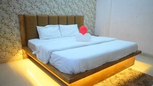 Une chambre moderne avec un cadre de lit en bois, une literie blanche et un papier peint à motifs floraux.