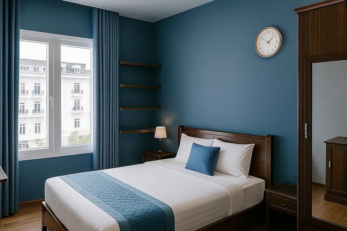 A bedroom with a bed, a nightstand, a dresser, a window with curtains, and a wall clock.
